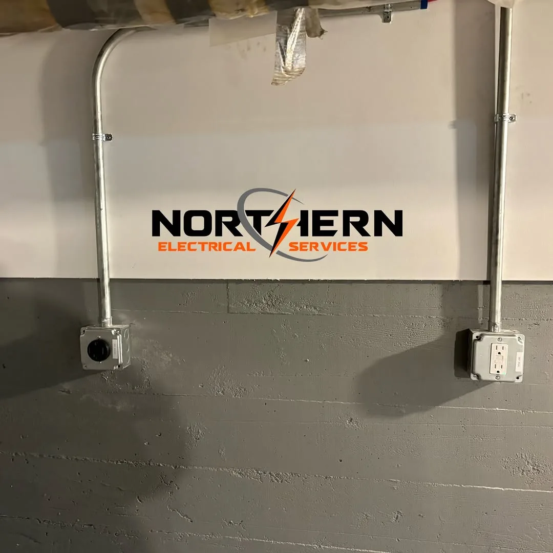 Conduit drops feeding outlets along basement wall